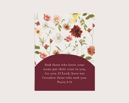 A vertical floral card or print with a white background decorated with watercolor-style flowers in pink, red, yellow, and green, plus a dark burgundy lower section containing a Bible verse from Psalm 9:10.
